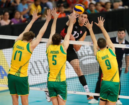 Gavin Schmitt (12) goes up for the spike against Australian blockersin