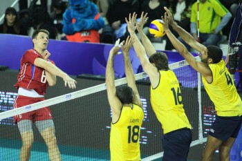 Evgeny Sivozheiez (left) of Russia spikes against Dante, Lucas and Wallace (BRA)